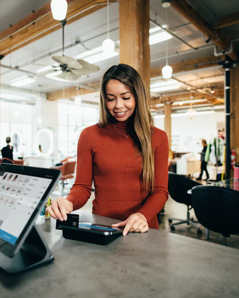 A café owner taking a card payment at the counter